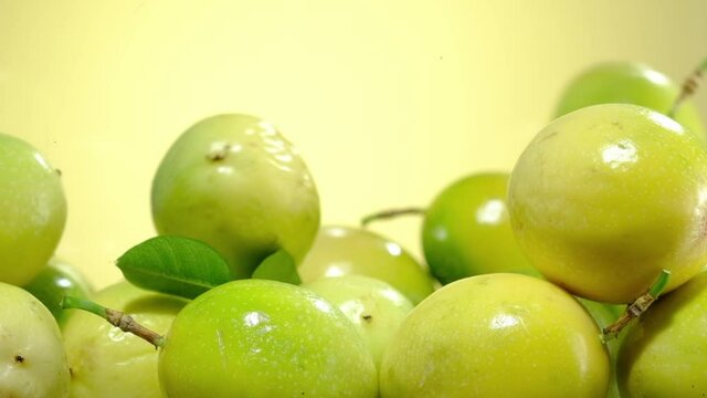 Slowmotion of passion fruit falling down with a yellow background 