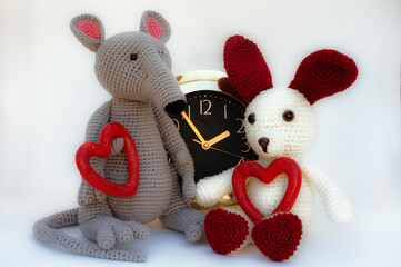 Amigurumi dolls  sit on the background of. Hearts.