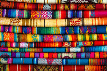 Pile of andean fabric on Otavalo handicraft market near Quito, Ecuador. - obrazy, fototapety, plakaty