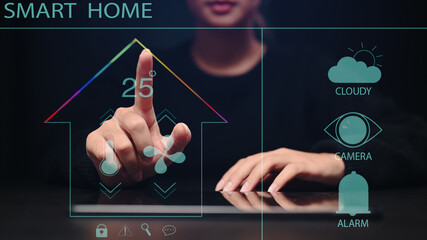 Young woman controlling all the functions on a virtual screen of futuristic interface of smart home automation assistant.