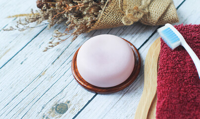 Handmade herbal glycerin soap laid on old wooden floor., Towels and toothbrushes are provided.