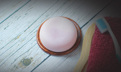 Handmade herbal glycerin soap laid on old wooden floor., Towels and toothbrushes are provided.