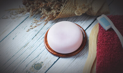 Handmade herbal glycerin soap laid on old wooden floor., Towels and toothbrushes are provided.