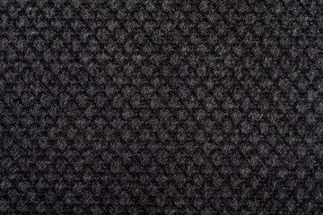 Black fabric texture. Furniture upholstery textiles. Embossed pattern. Woven fibers. The material is soft touch. Minimalism concept. High detail macro photography for backgrounds or wallpapers.