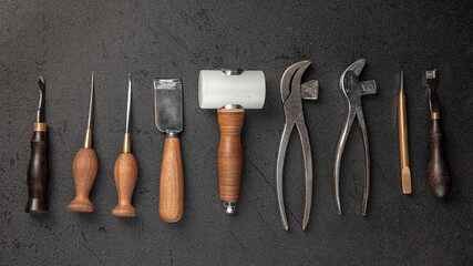 Set of leather craft cobbler tools on black background
