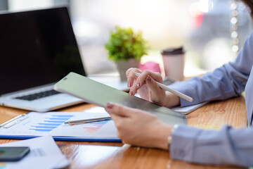 Close up of young businesswoman using digital tablet in the office.