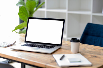 Laptop computer with blank white screen on table.