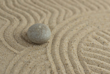 Fototapeta na wymiar Zen sand garden meditation stone background with copy space. Stones and lines drawing in sand for relaxation. Concept of harmony, balance and meditation, spa, massage, relax