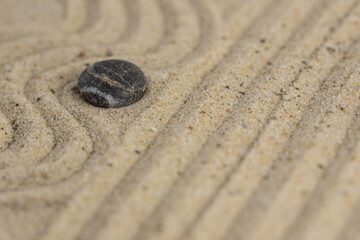 Zen sand garden meditation stone background with copy space. Stones and lines drawing in sand for relaxation. Concept of harmony, balance and meditation, spa, massage, relax