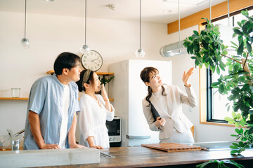 キッチンの設備を説明する女性（換気扇）