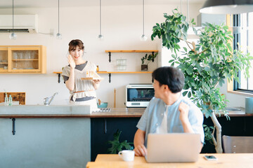 Obraz premium テレワークする男性とキッチンにいる女性 