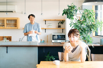 Fototapeta premium 家でくつろぐ仲の良い夫婦（スマホ） 
