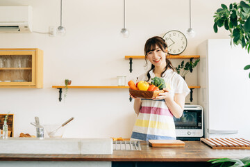 キッチンで野菜を持つ女性
