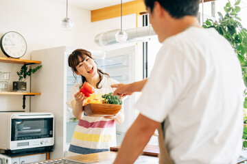 冷蔵庫の前に立つ女性と男性（野菜）
