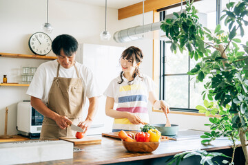 一緒に料理を作る男女（夫婦・フライパン）
