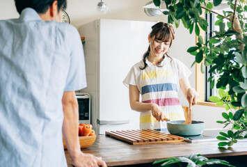 一緒に料理を作る男女（夫婦・フライパンと野菜）
