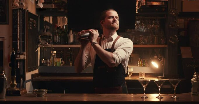 Caucasian male bartender mixing drinks for cocktails shaking mixers 