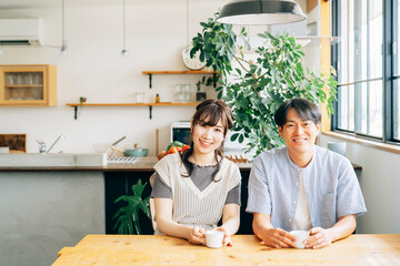 おしゃれ空間でコーヒーを飲む男女（カメラ目線）
