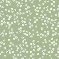 Vintage floral background. Seamless vector pattern for design and fashion prints. Elegant floral pattern with small white flowers on a green background.