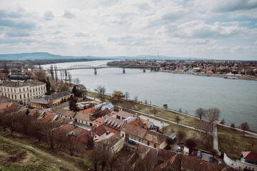 A panoramic view of the Mária Valéria Bridge spanning the Danube River, connecting the cities of Esztergom, Hungary, and Párkány (Štúrovo), Slovakia. The image captures the bridge, the river, and the 
