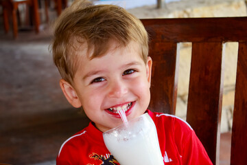 Little boy drinking milkshake through a straw