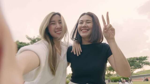 Two young woman friends taking selfie self-portrait photos on smartphones and enjoying travel on vacation.