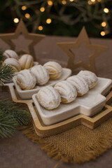 Fototapeta na wymiar Nut-shaped cookies sprinkled with powdered sugar in a Christmas tree-shaped ceramic dish.