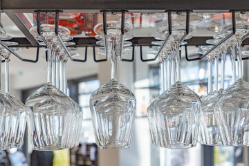 clean wine glasses hanging in a rack