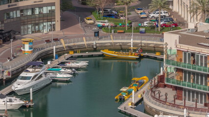 Fototapeta na wymiar Waterfront promenade with palms in Dubai Marina aerial timelapse.