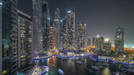 Fototapeta na wymiar Dubai marina tallest skyscrapers and yachts in harbor aerial night timelapse.