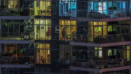 Flat night panorama of multicolor light in windows of multistory buildings aerial timelapse.