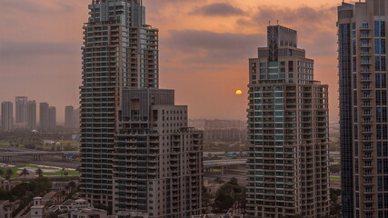 Fototapeta na wymiar Sunrise over Dubai Marina luxury tourist district with skyscrapers and towers around canal aerial timelapse