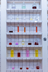 Laboratory cabinet with colorful vials, flasks and tubes containing medicine liquids.