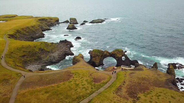 Amazing seascape, Gatklettur basalt rock arch at the volcanic cliff, Atlantic coast of Arnarstapi in the west of Iceland, natural background. Rocks and stones with abstract forms. Drone footage. 
