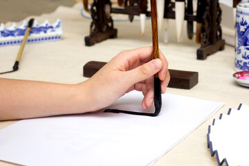 Traditional Chinese calligraphy Master writing a character. Asian art equipment and tools