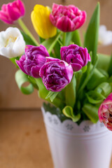 Mix of spring tulips flowers. Bouquet in a vase. Multi-colored spring flower. Gift. Red, pink, white and yellow. Background with flowers tulips close-up different colors.