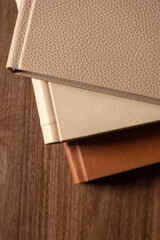 Stack of leather bound books against wooden background