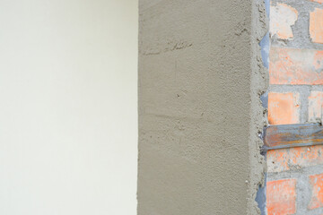 Construction concept. Cement plaster. The process of plastering a brick column.