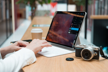 A freelance photographer works remotely, a thin mobile computer with a photo on the screen and a camera in the foreground. Creative work, retouching or creating designs.