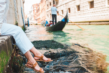 woman sitting at city quay at venice italy enjoying the view of canals with gondolas