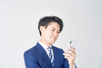 ビジネスマン　スマホ　考える　白背景