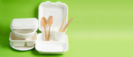Eco friendly biodegradable paper disposable for packaging food and paper glass on green background.