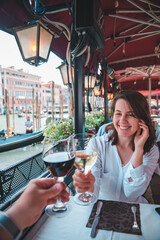 first person point of view couple in cafe outdoors drinking wine smiling woman
