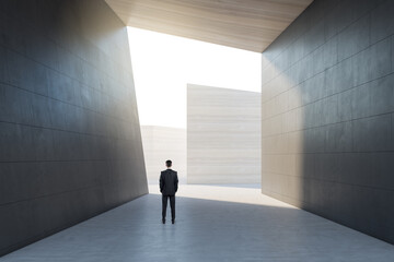 Male standing in abstract concrete tile space interior background with sunlght. Design and abstraction concept.