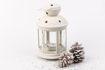 White lantern with candle inside and Christmas decoration on white background. Copy space.