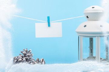 Christmas lantern with New Year's attributes and snow over on blue background.