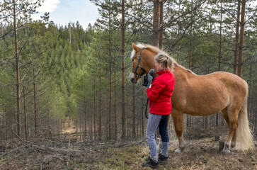 Woman walking with horse in forest
