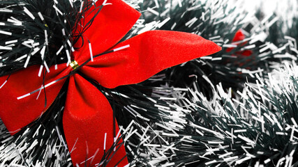 Closeup of Red Christmas ribbon on the snowy spruce 