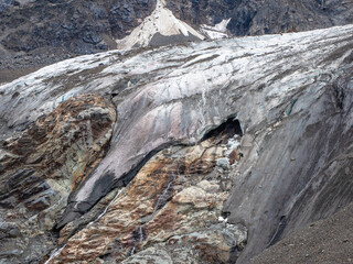 Melting glacier texture. Minimalist nature background of glacier surface with big cave and cracks. Minimal natural backdrop of icy wall and blocks of ice from glacier close up.