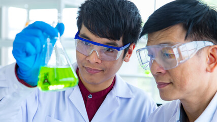 Closeup shot of Asian happy young successful professional male scientist student face in white lab...